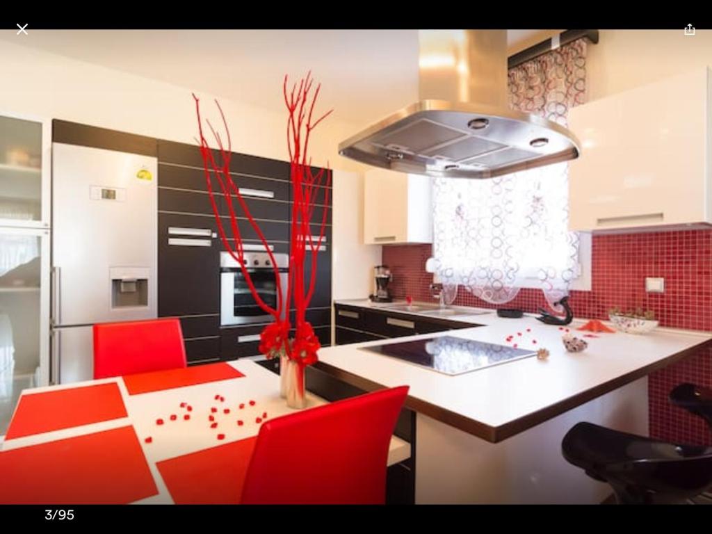 帕拉利亚卡泰里尼斯Artisti Elena的一间带红色椅子的厨房和一个带炉灶的厨房岛
