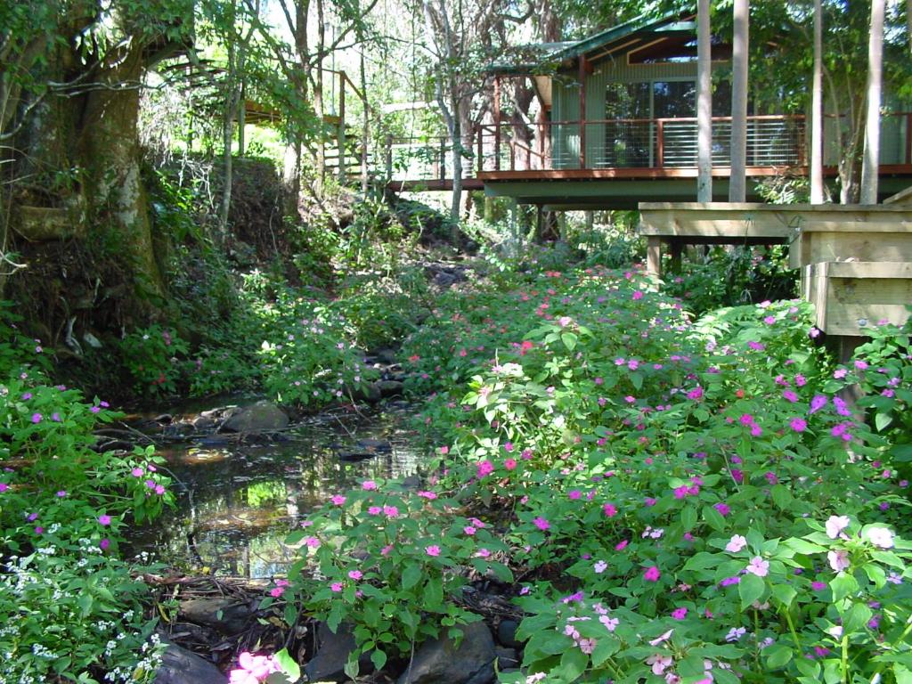 蒙特维尔特里托普蒙特维尔度假村的一座花园,花园内种有粉红色的花卉,一座桥梁