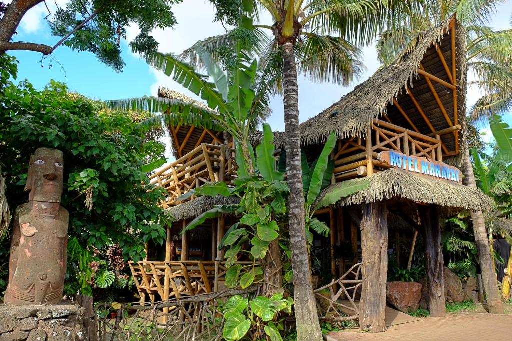 安加罗阿玛妮威酒店的热带房屋,带草屋顶和棕榈树