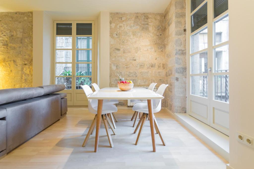 赫罗纳Bravissimo Cort Reial-1B的一间设有白色桌子和白色椅子的用餐室