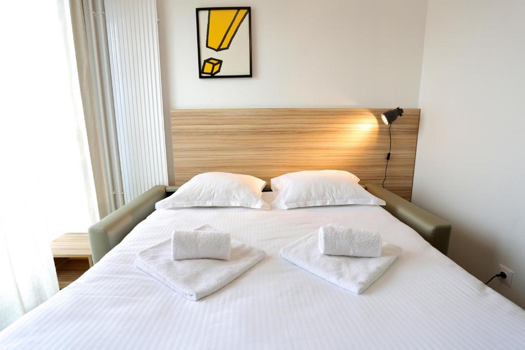 第戎第戎公寓式酒店的一张白色的床,上面有两个白色的枕头