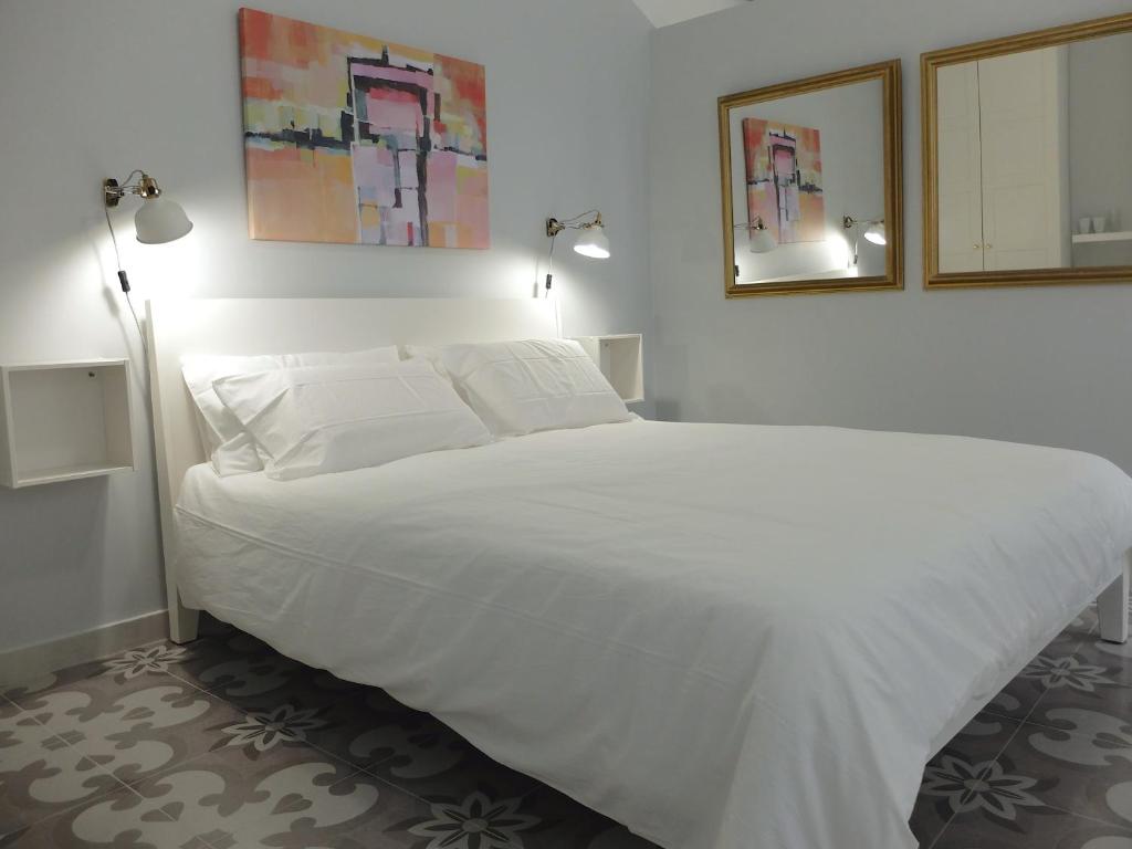 比尔古No. 17 Birgu的卧室里一张大白色的床,有两盏灯