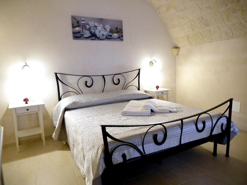 滨海波利尼亚诺Le Arcate的一间卧室配有一张黑白床和两张桌子