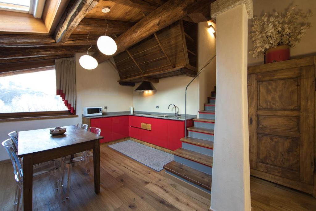 因特罗德Maison Lo Triolet的厨房配有红色橱柜、桌子和楼梯