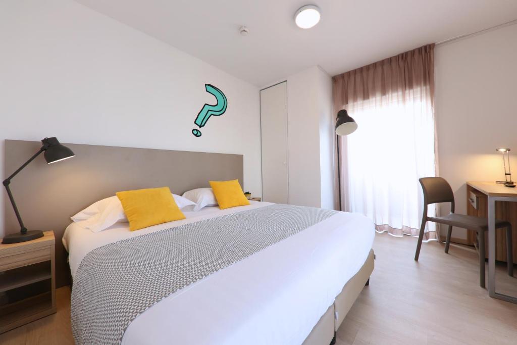 波尔多Apparteo Bordeaux的卧室配有一张带黄色枕头的大型白色床。