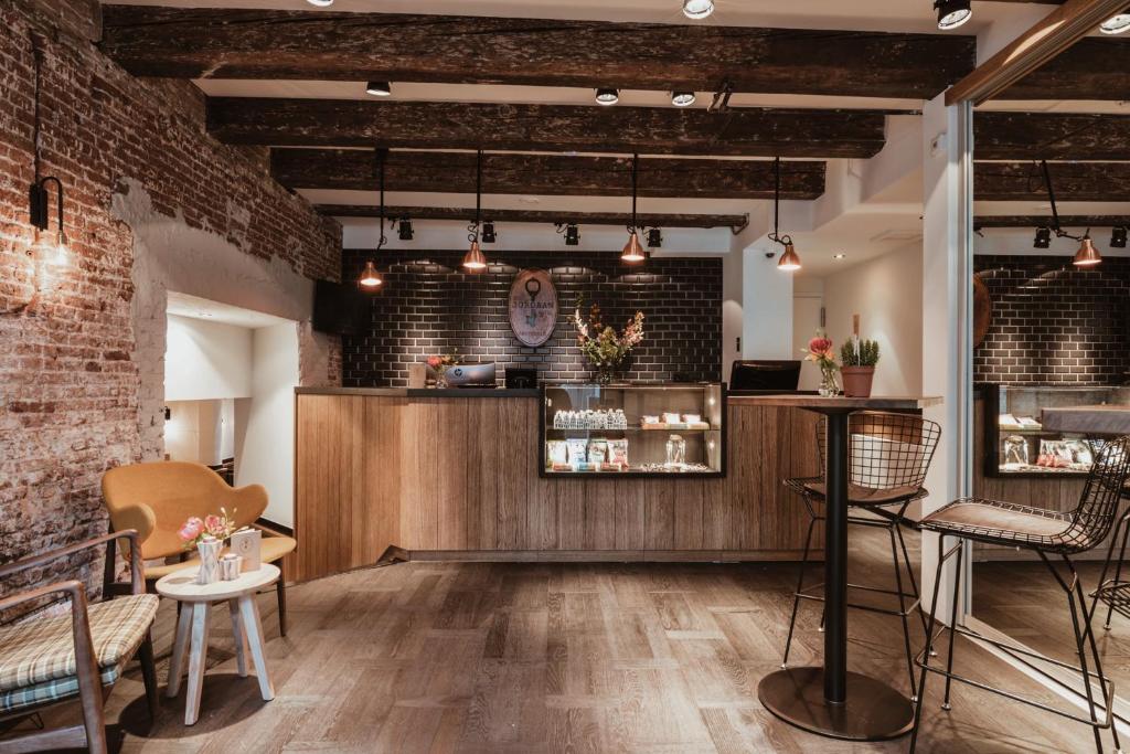 阿姆斯特丹乔丹先生酒店的餐厅设有砖墙和带椅子的柜台。