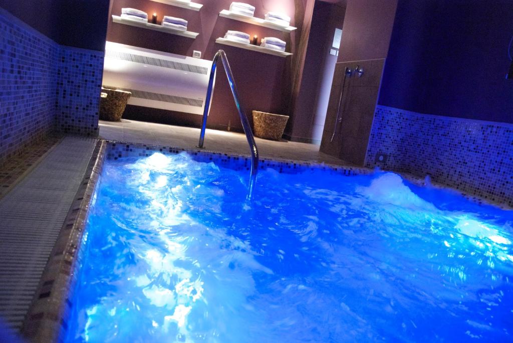 里米尼Sovrana Hotel & SPA的浴室里有一个蓝色的大池子