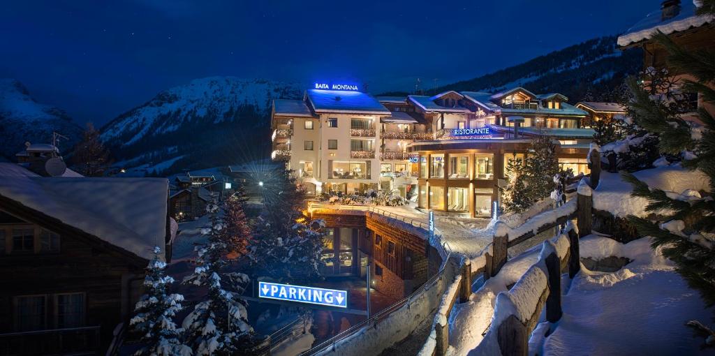 利维尼奥Hotel Baita Montana的雪中,晚上在山里的一家酒店