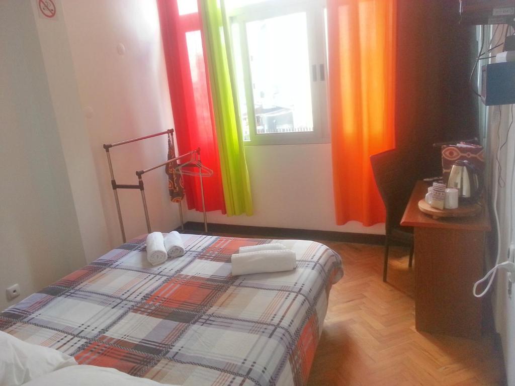 马普托The Quiet Corner Guest House的卧室配有色彩鲜艳的窗帘和1张床