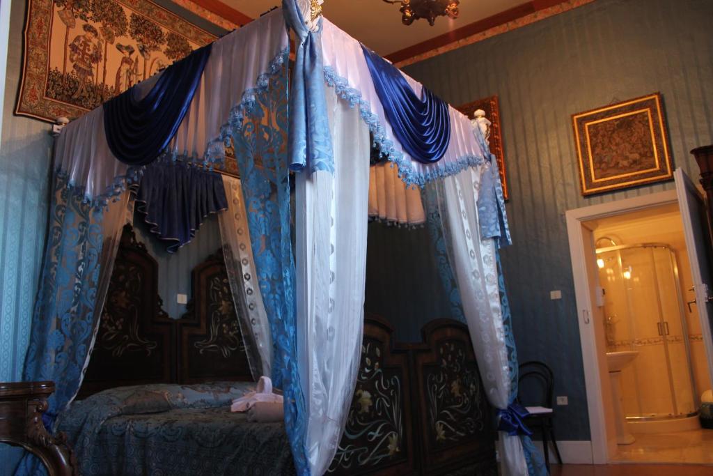ArenaB&B Domenico Cesarelli的一间卧室配有一张带蓝色窗帘的天蓬床