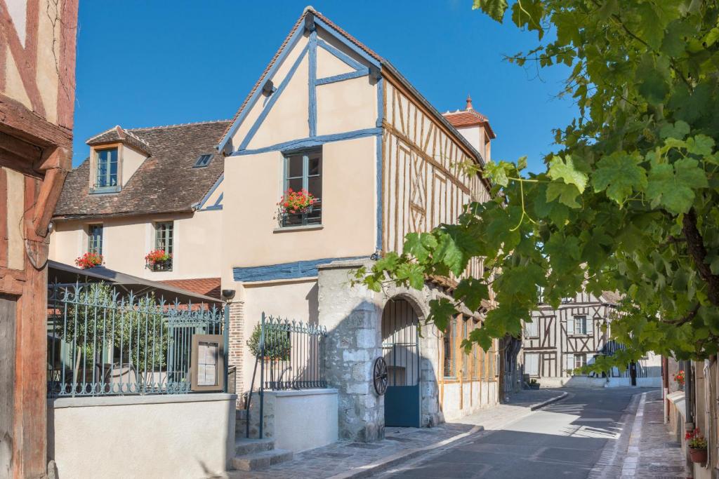 普罗万Hôtel Aux Vieux Remparts, The Originals Relais的水边的中世纪小镇伯顿的一条街道