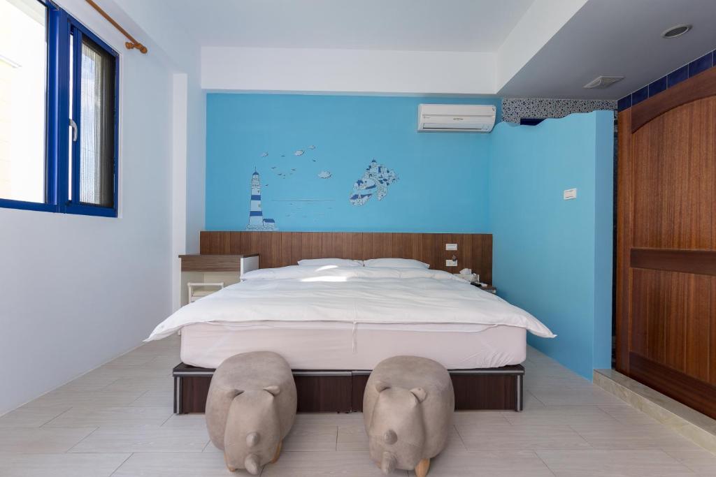 马公旅人灯塔的卧室配有一张大床,地板上设有两张大象头