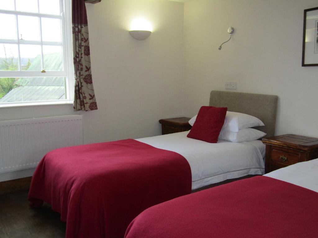 Newent基尔科特宾馆的酒店客房设有两张床和窗户。