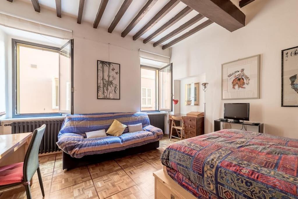 帕尔马Studio Borgo Colonne的一间卧室配有一张床和一张沙发