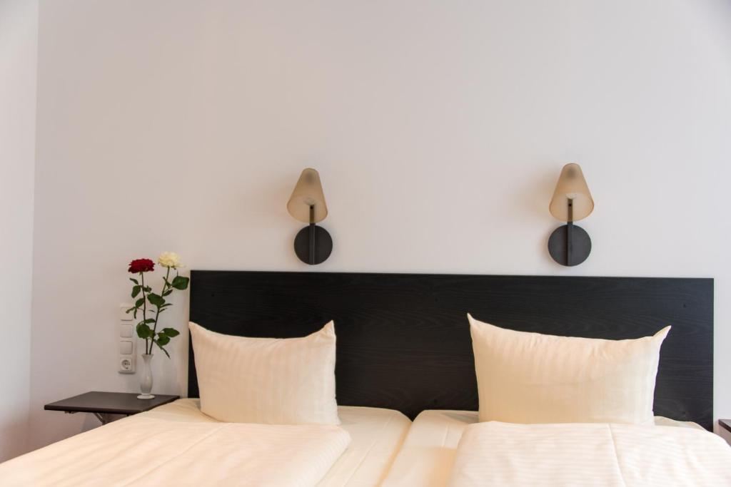 布伦瑞克宫廷酒店的一间卧室,配有一张带两盏灯的床。
