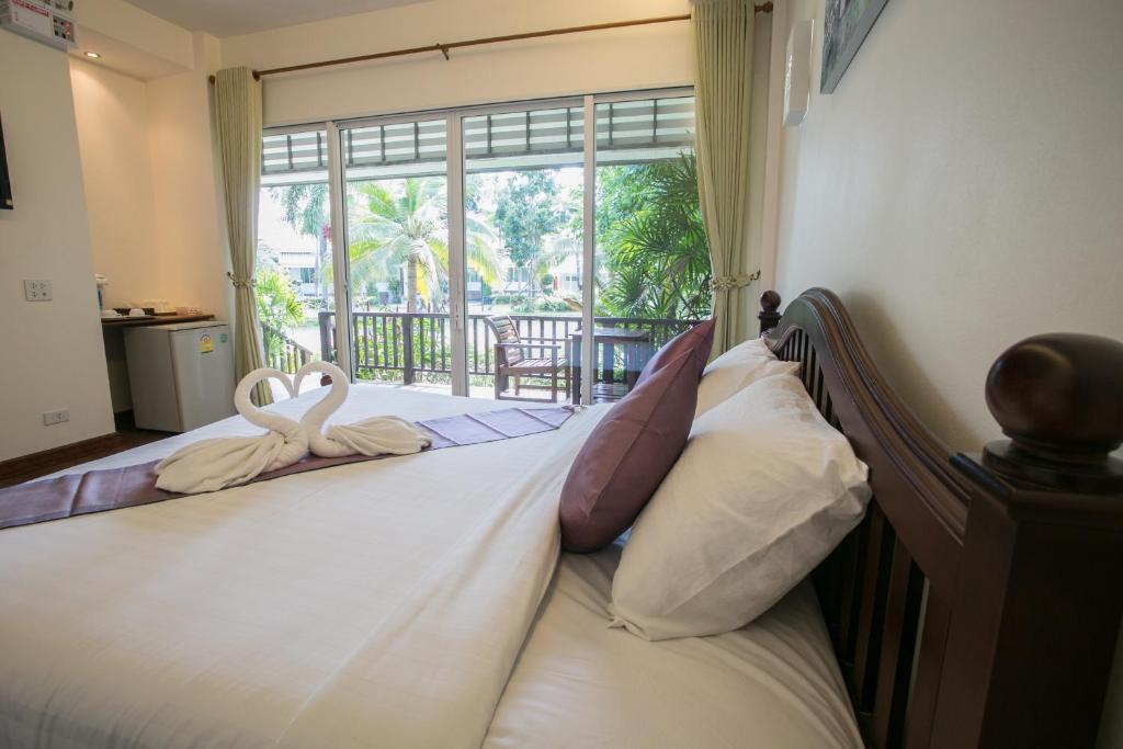 林信尼萨斯丽精品度假酒店的一间卧室配有一张带天鹅毛巾的床
