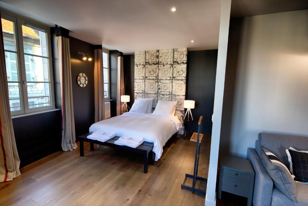 阿尔布瓦Le Comptoir du Voyageur的一间卧室设有床、两个窗户和一张沙发