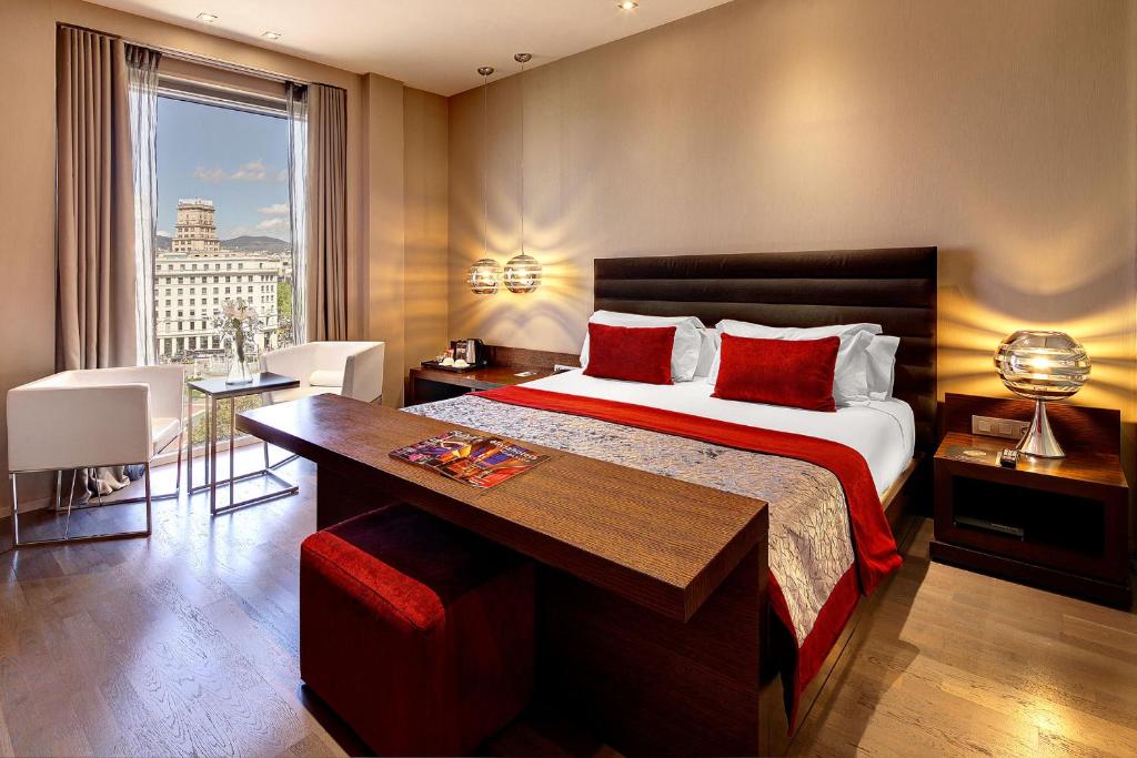 巴塞罗那奥利维亚宫酒店的一间卧室配有一张床、一张书桌和一个窗户。