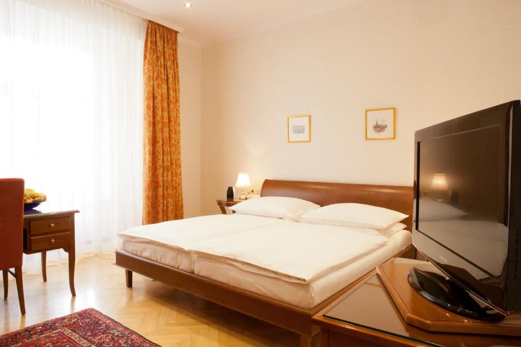 维也纳伊丽莎白皇后酒店的一间卧室配有一张床和一台平面电视