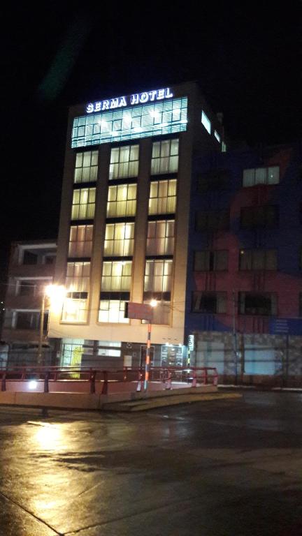 波托西Apart Serma Hotel的一座建筑物,上面有夜间标志