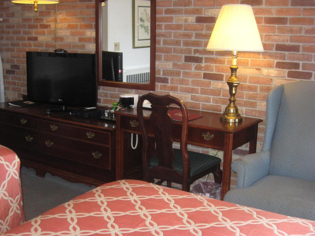 洛克波特洛克波特套房酒店的一间卧室配有一张桌子、一台电视和一把椅子