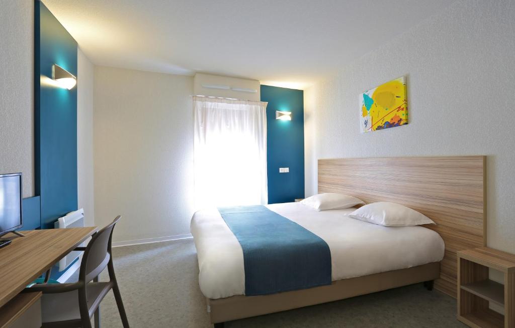 马赛马赛公寓式酒店的一间卧室配有一张床、一张书桌和一个窗户。