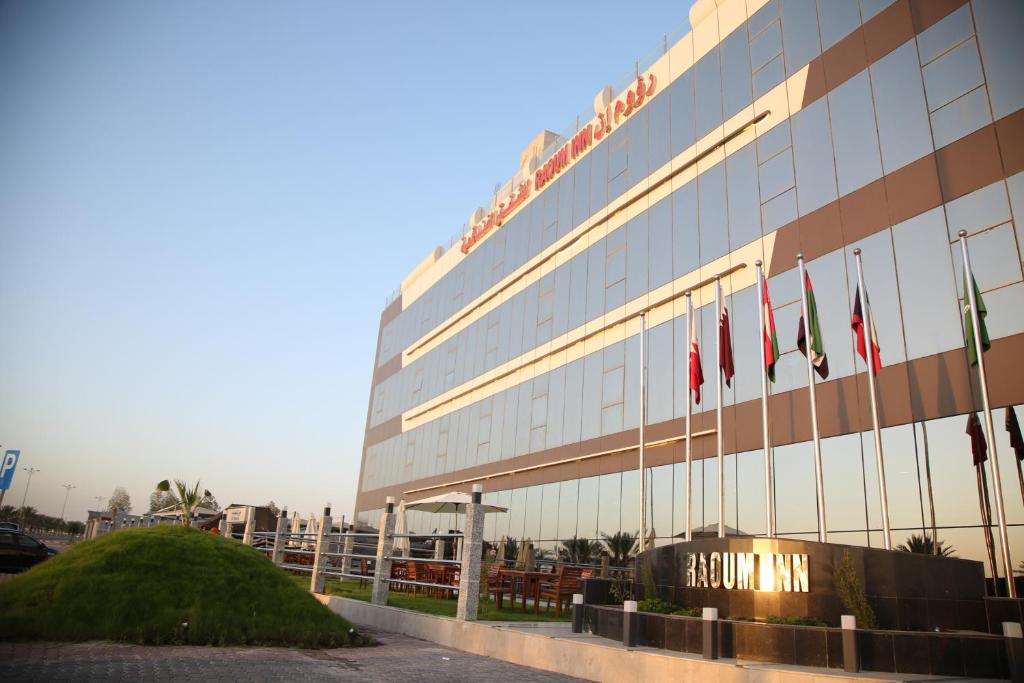 阿尔卡夫奇Raoum Inn Khafji Corniche的前面有旗帜的建筑