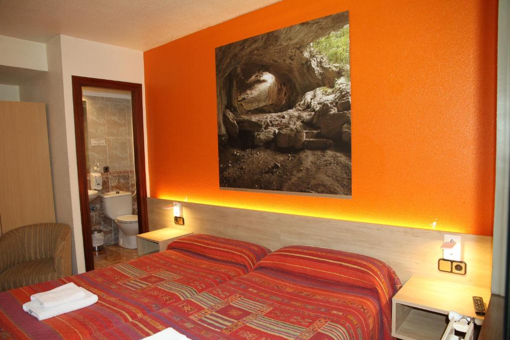潘普洛纳阿瑟拉旅馆的一间卧室配有一张橙色墙壁的床