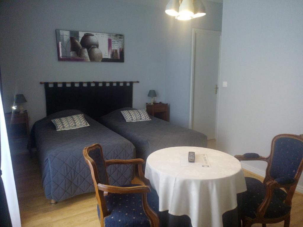 谢尔河畔努瓦耶乐克洛斯切尔酒店的一间卧室配有两张床和一张桌子及椅子