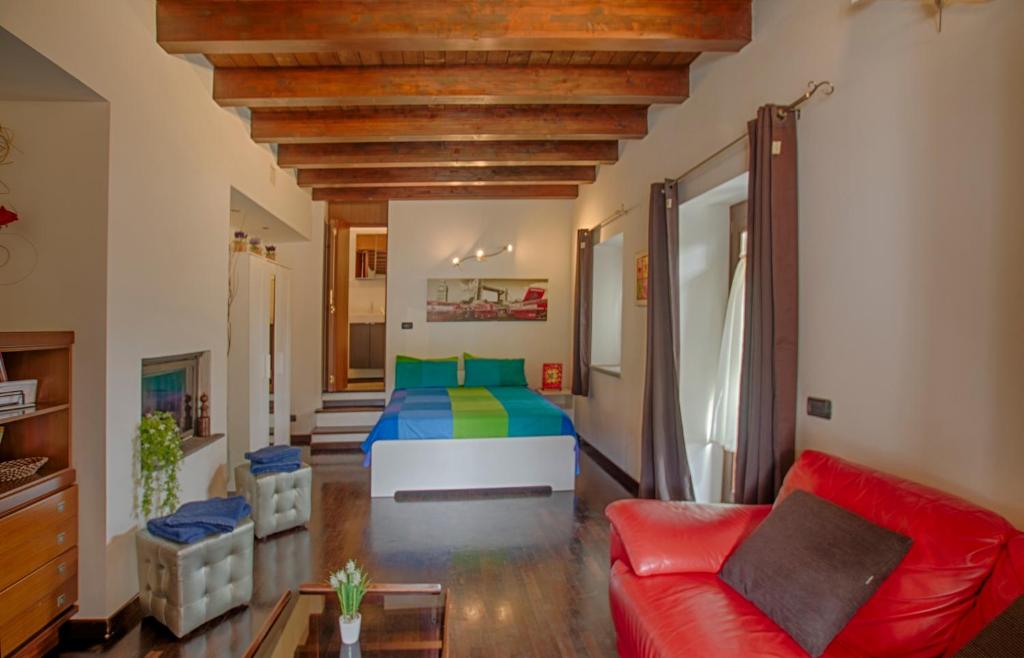 布拉恰诺卡萨莱普拉托特拉度假屋的客厅配有床和红色沙发