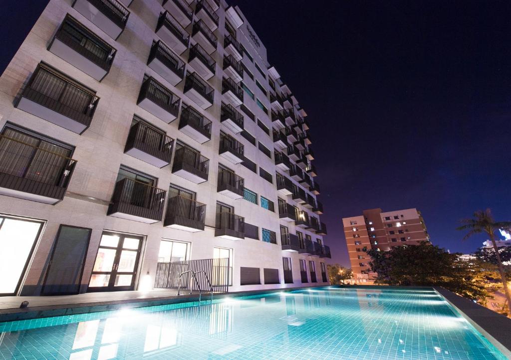 花莲市Kadda Hotel (玺宾行旅)的一座游泳池,在晚上在建筑物前