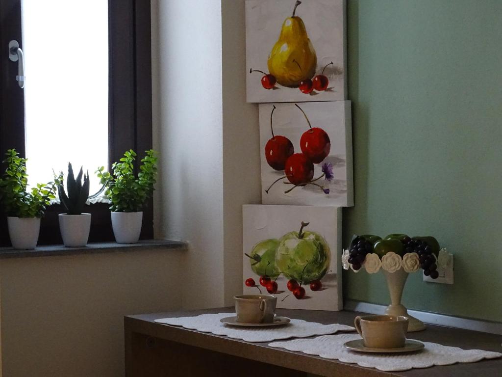 普拉托埃米利奥公寓的一张桌子,上面有两杯,还有一些植物和画
