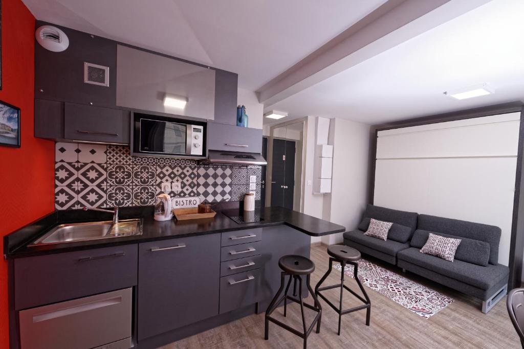 里昂里昂在家公寓式酒店的一个带水槽的厨房和一张沙发