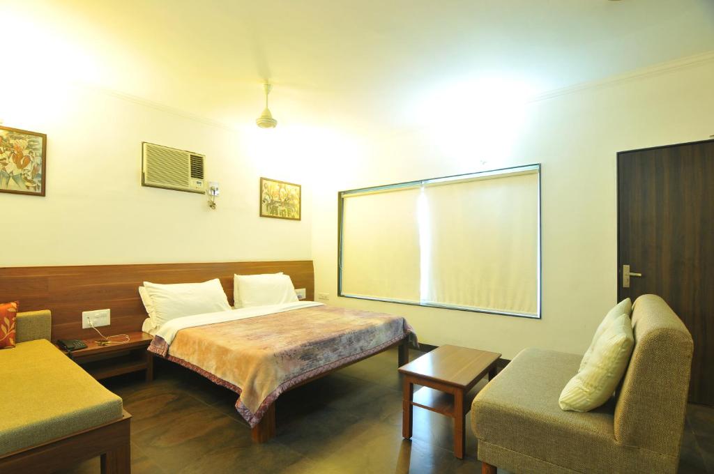 博帕尔Lago villa的客房设有床、沙发和窗户。