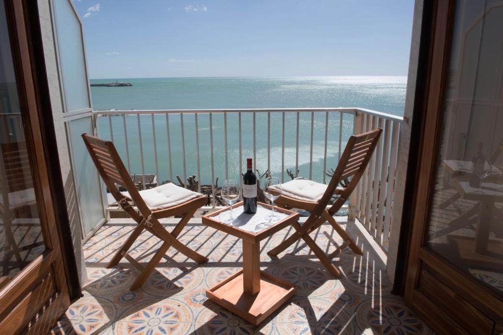 夏卡Appartamento Mare Blu的阳台配有一张桌子和两把椅子,享有海景