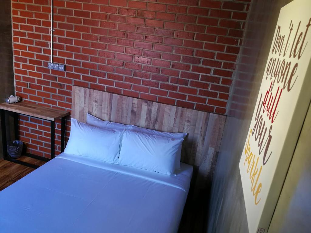 瓜拉丁加奴莱斯宾馆的砖墙房间的一个床位