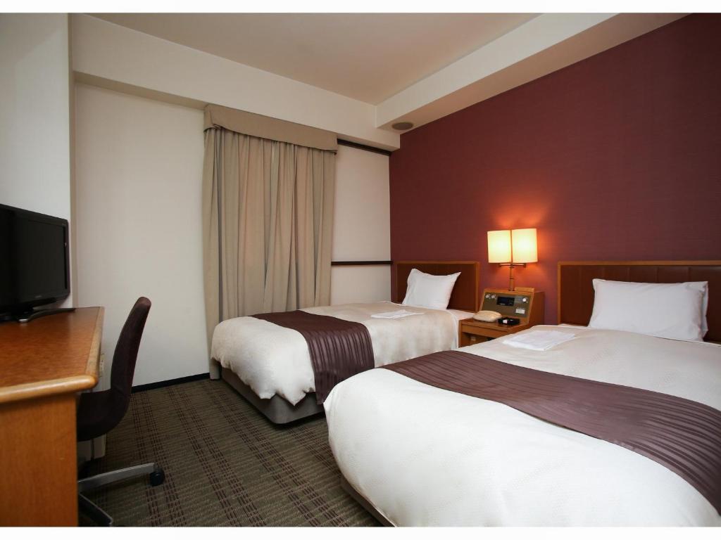 郡山郡山华盛顿酒店 的酒店客房设有两张床和一台平面电视。