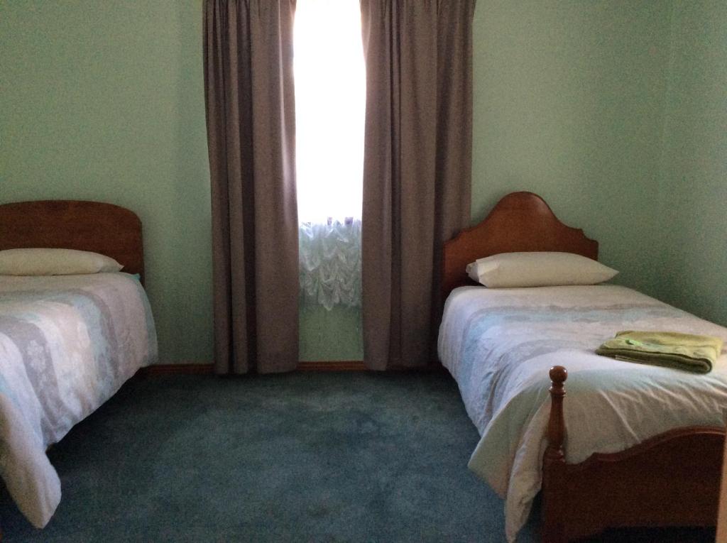 罗斯奥尔度假屋的一间卧室设有两张床和窗户。