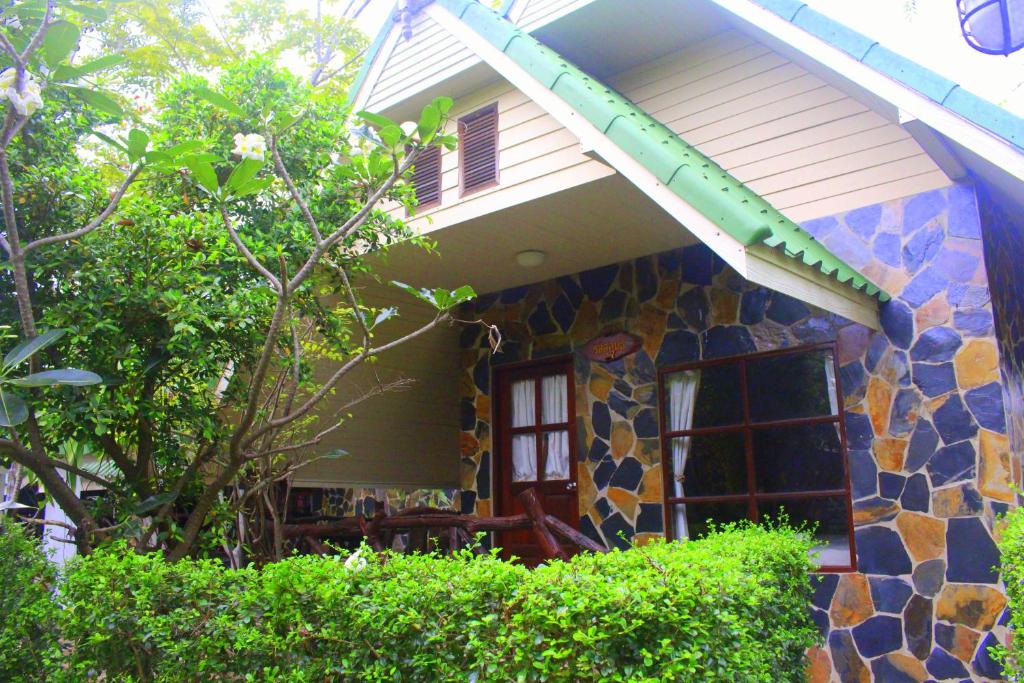 哈德超珊兰乌贼度假村 的一座石头房子,设有绿色遮阳篷和窗户