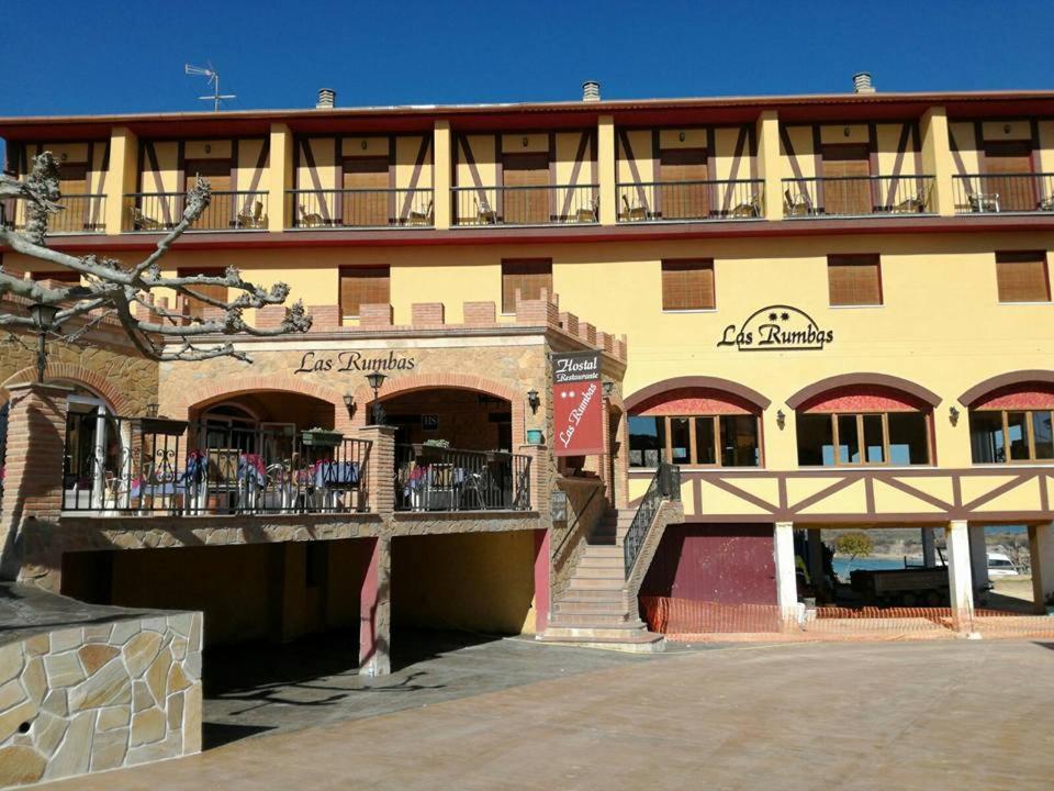 努瓦洛斯拉斯茹姆巴斯酒店的一座黄色的大建筑,设有阳台和楼梯