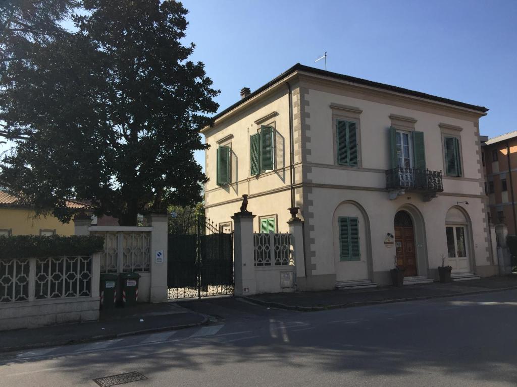 卢卡Lucca Relais的白色的房子,有栅栏和树