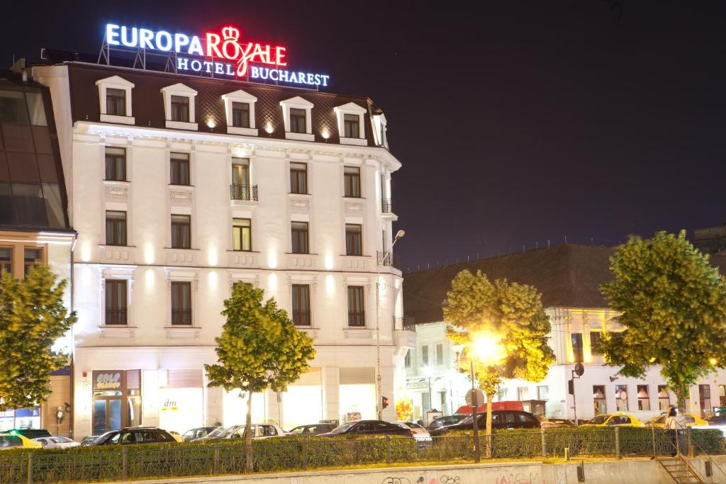 布加勒斯特欧洲酒店皇家布加勒斯特的一座白色的大建筑,上面有 ⁇ 虹灯标志