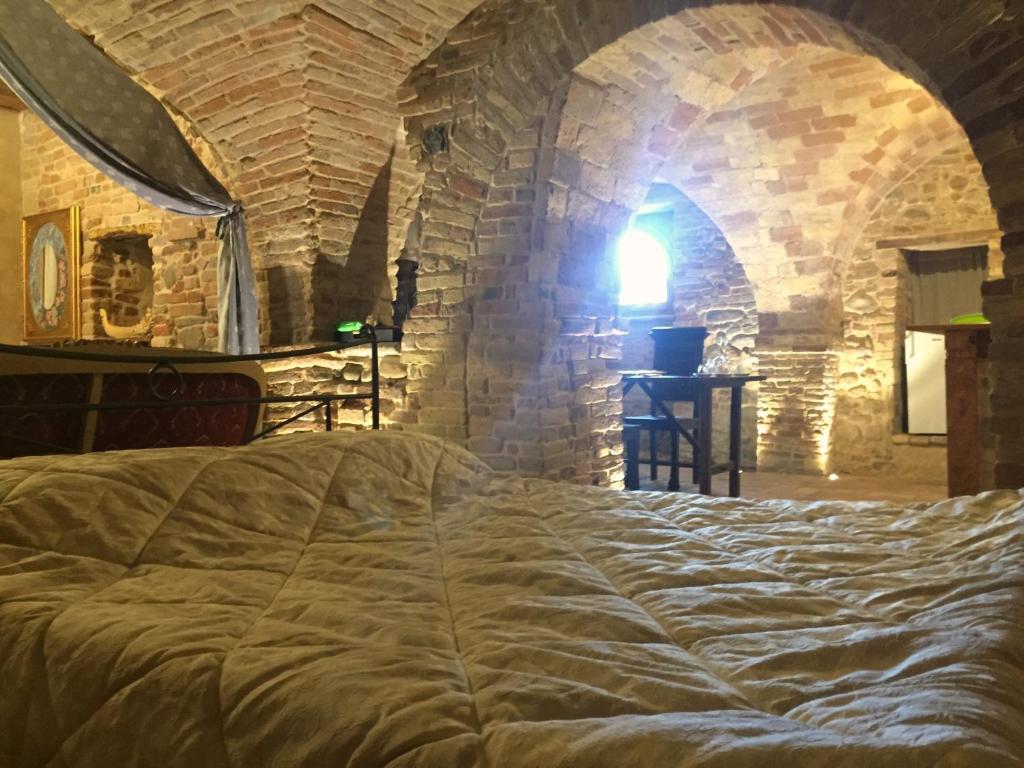 SpinetoliPantorano rooms的卧室配有一张石墙内的大床
