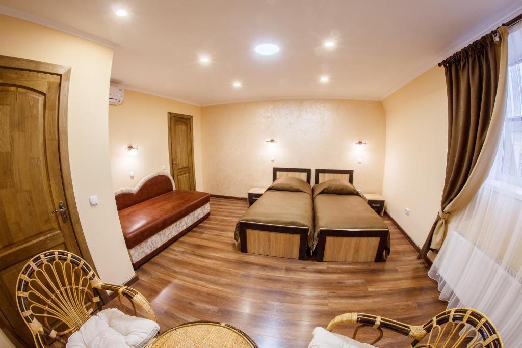 卡缅涅茨-波多利斯基Panorama Apart-Hotel的酒店客房,设有两张床和一张沙发