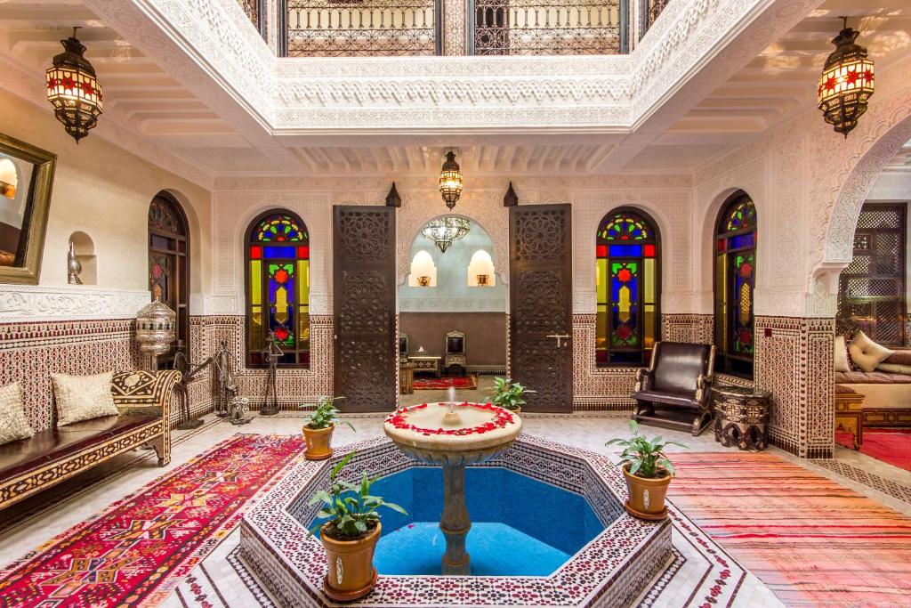 马拉喀什马拉喀什拉米亚摩洛哥传统庭院住宅的一间客厅,位于大楼中央,设有游泳池