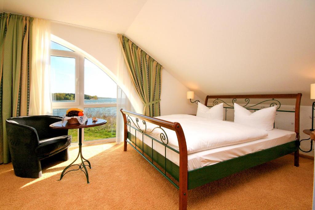 普特布斯诺迪鲁斯酒店的卧室配有床、椅子和窗户。