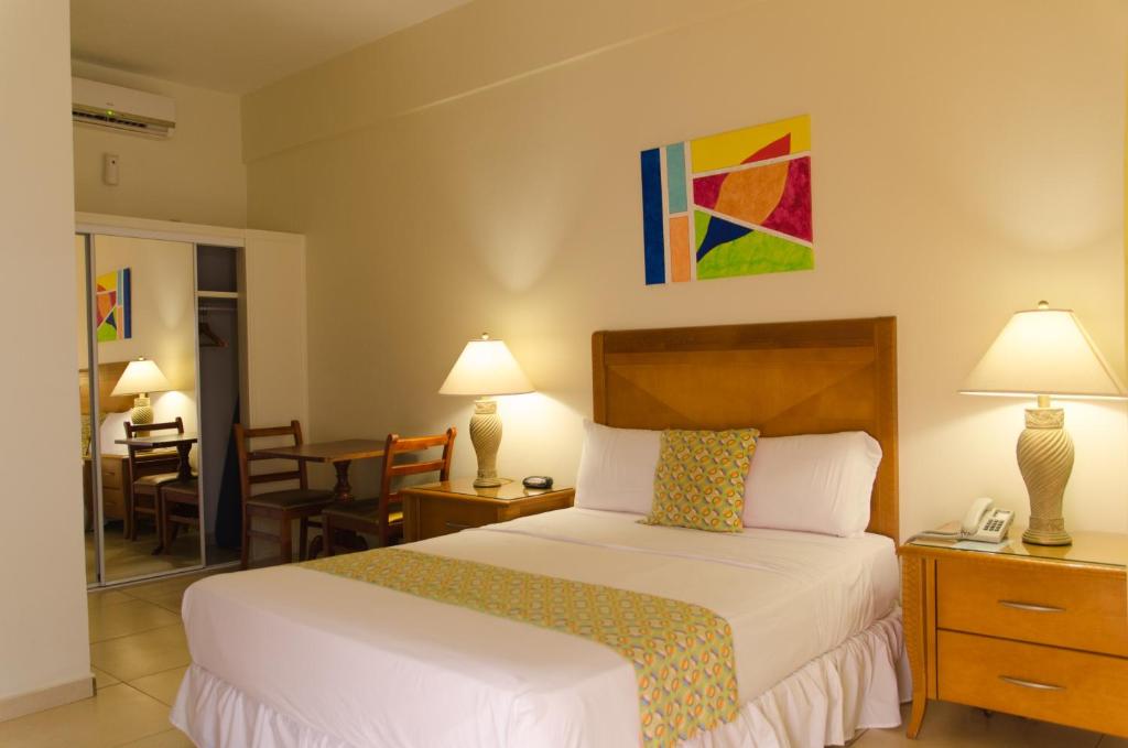 菲利普斯堡艾丽西亚旅馆的酒店客房带一张床、一张桌子和椅子