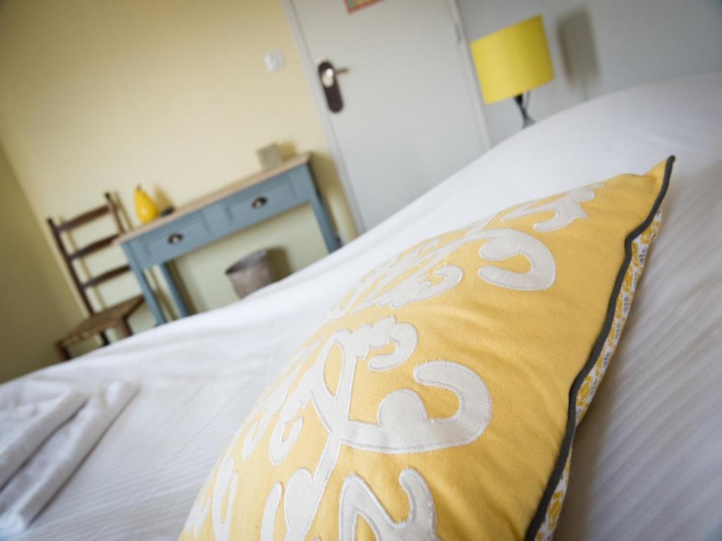 VervinsLogis Hotel Restaurant Le Relais Fleuri的床上的黄色和白色枕头