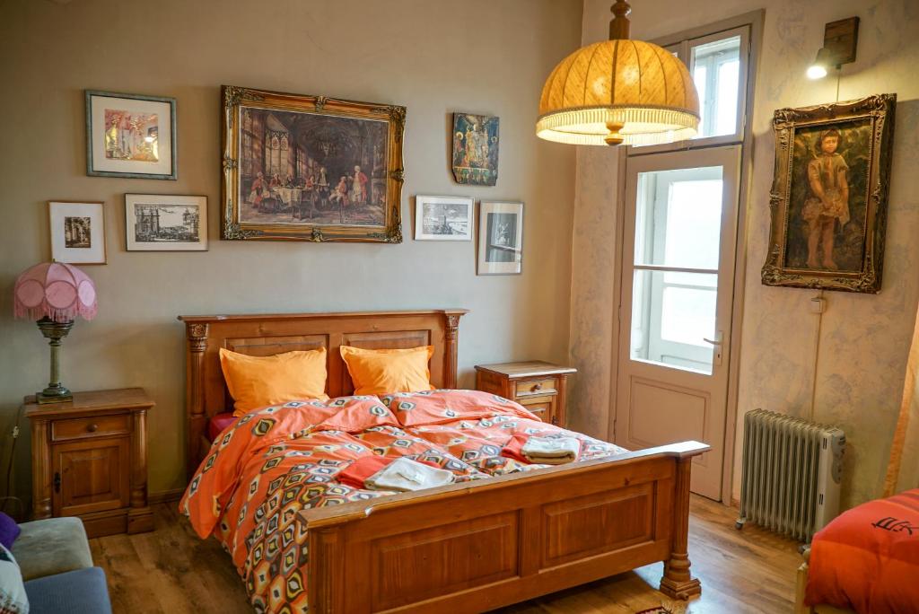 大特尔诺沃鲁斯特旅舍的一间卧室设有一张床和一个窗户,墙上挂着图片
