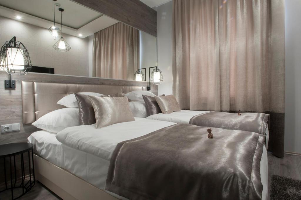 凯奇凯梅特塔里兹曼酒店的一间卧室设有两张床和大镜子